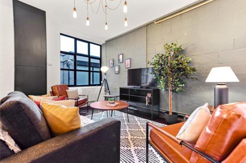 a living room with couches and a tv at Trendy and Eccentric Flat in Hackney in London