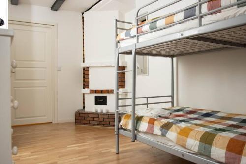 a bedroom with a bunk bed and a fireplace at Historical Malt Factory Apartment, 6 Bedrooms, sleeps 12 , Hot Tub in Helsingborg