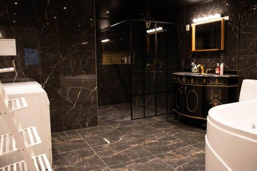 a black bathroom with a shower and a sink at Historical Malt Factory Apartment, 6 Bedrooms, sleeps 12 , Hot Tub in Helsingborg