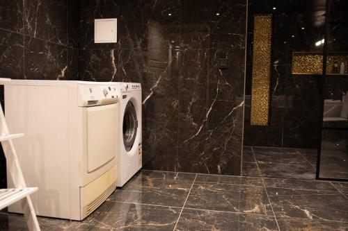 a washer and dryer in a black marble bathroom at Historical Malt Factory Apartment, 6 Bedrooms, sleeps 12 , Hot Tub in Helsingborg