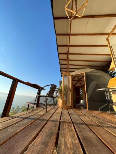 a deck with a tent and chairs on a roof at Domo Jacuzzi con vista al Cañón del Chicamocha in Los Santos