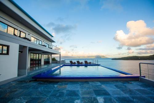 una piscina sul lato di un edificio con vista sull'acqua di Horizon Hotel Romblon a Romblon