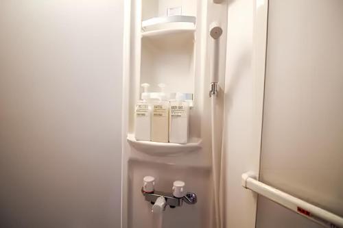a door open to a bathroom with a shelf at Yagara Terrace House D in Osaka