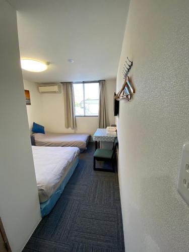 a hotel room with two beds and a door at MR TOMO FUJI in Fuji