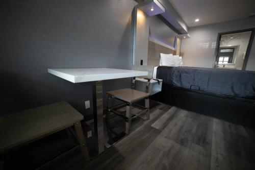 a small room with a sink and a bed at Travelodge by Wyndham Whittier in Whittier