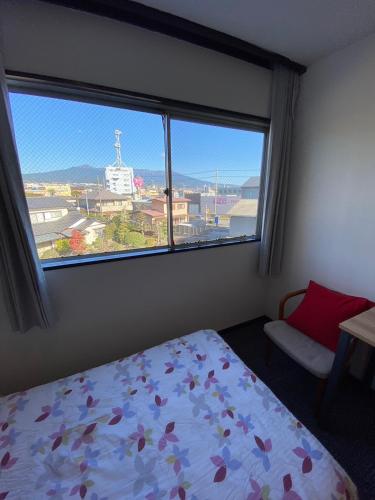 a bedroom with a bed and a large window at MR TOMO FUJI in Fuji