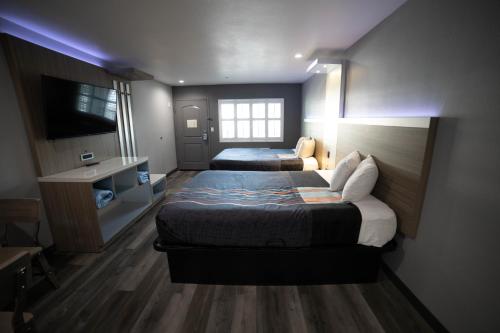 a hotel room with two beds and a television at Travelodge by Wyndham Whittier in Whittier