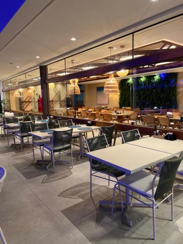um restaurante com mesas e cadeiras numa cafetaria em Makia Beach Experience em Ipojuca