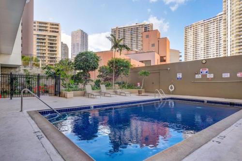 a swimming pool with buildings in the background at Waikiki condo -18F in Honolulu