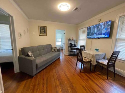 sala de estar con sofá, mesa y sillas en Entire Cozy 1BR Apartment in heart of Queens L en Whitestone