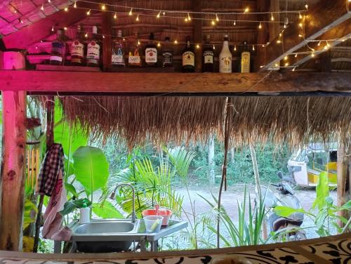 un bar con botellas de alcohol en un estante en The Cocoon en Phumĭ Chroŭy Svay