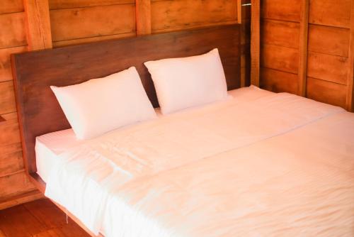 Una cama con dos almohadas blancas encima. en Ceylon Nature Paradise, en Uragasmanhandiya