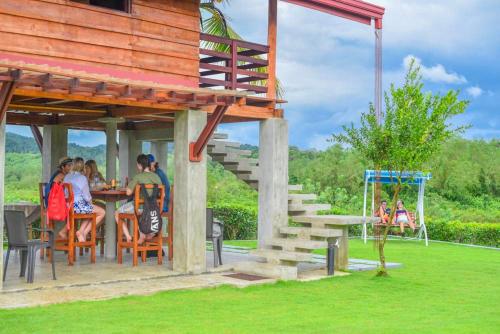 a group of people sitting at a table under a building at Ceylon Nature Paradise in Uragasmanhandiya