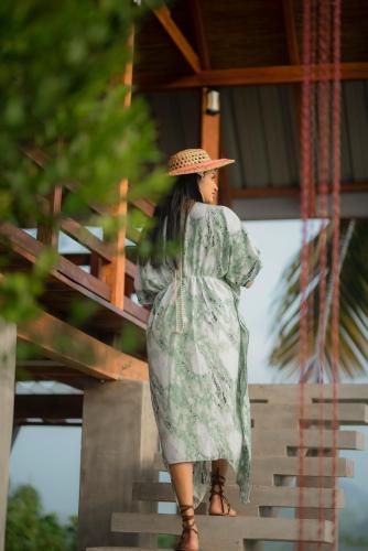 a woman in a dress and hat walking down stairs at Ceylon Nature Paradise in Uragasmanhandiya