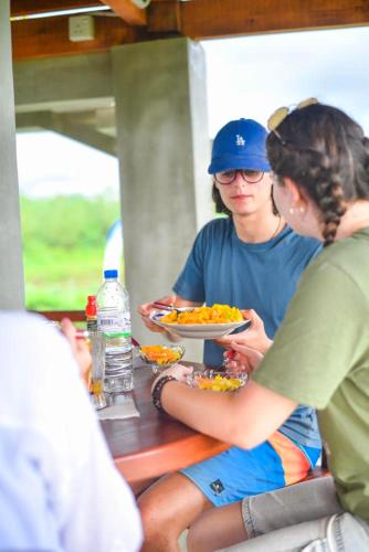a group of people sitting at a table eating food at Ceylon Nature Paradise in Uragasmanhandiya