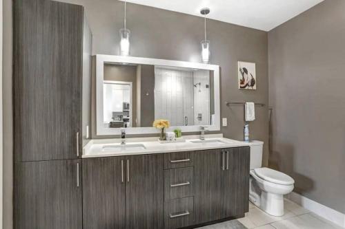 W łazience znajduje się umywalka, toaleta i lustro. w obiekcie 1BR Oasis in Downtown Tampa w Balcony & City Views w mieście Tampa