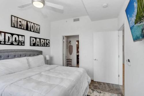1BR Oasis in Downtown Tampa w Balcony & City Views في تامبا: غرفة نوم مع سرير أبيض كبير في غرفة