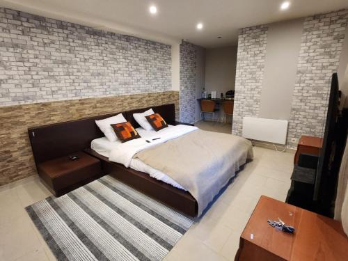 1 dormitorio con 1 cama grande y pared de ladrillo en Nuit aimable, en Biot