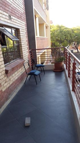 two chairs sitting on a balcony of a building at Legacy Guest Lodge in Johannesburg