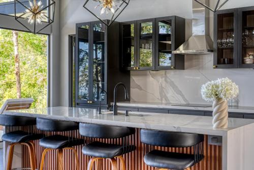 a kitchen with a large island with leather bar stools at Brisas Del Mar Hills of Portalón Ocean View in Savegre