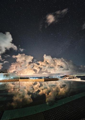 a starry night with a pool and the sky at Apec MANDALA CHAM BAY MUI NE SPA RESORT AND CONDOTEL in Ấp Thiẹn Ái