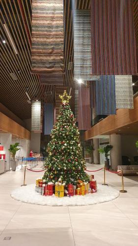 a christmas tree in a room with presents around it at Apec MANDALA CHAM BAY MUI NE SPA RESORT AND CONDOTEL in Ấp Thiẹn Ái