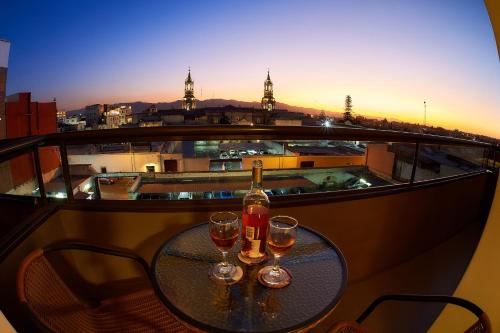 einen Tisch mit zwei Gläsern Wein auf dem Balkon in der Unterkunft ARIQUEPAY HOTEL in Arequipa