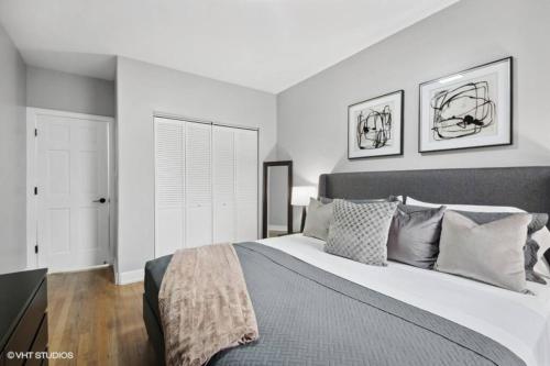 a white bedroom with a large bed with pillows at The Chic Urban Oasis Near the Lake! in Chicago