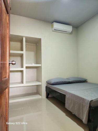 a bedroom with a bed and a book shelf at Peluza's place in Puerto Jiménez