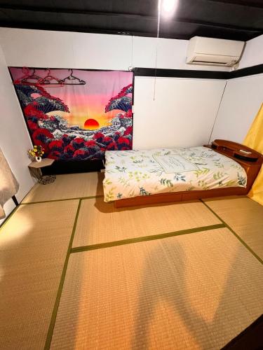 a room with a bed and a painting on the wall at SnowHouse in Tokyo