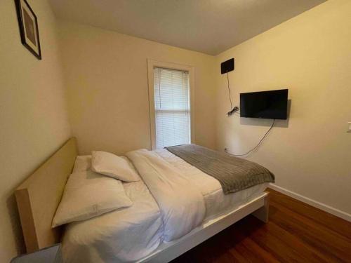 1 dormitorio con 1 cama y TV en la pared en Entire Beautiful 1BR for You! [R] en Whitestone