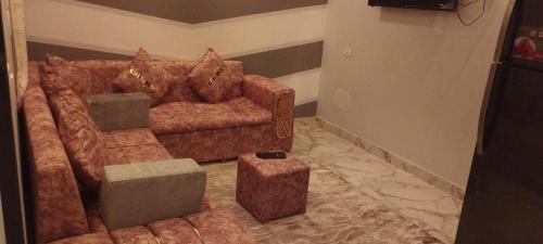 شقة مفروشة للايجار 4 في المنصورة: غرفة معيشة مع أريكة بنية ومقعد