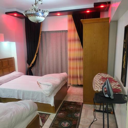 a bedroom with two beds and a chair in it at شقه فى ميامى بالاسكندريه مطله على البحر in Alexandria