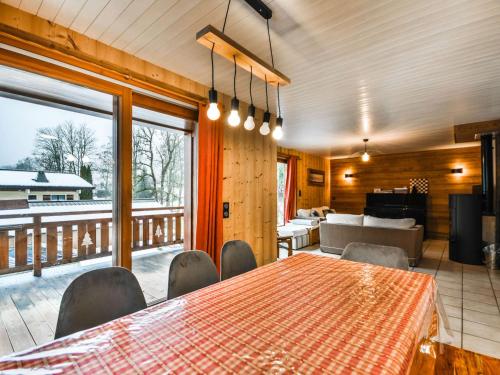 une salle à manger avec une table et des chaises et un balcon dans l'établissement Chalet familial confortable 7 pers, 800m des pistes, terrasse, parking, WiFi, équipements modernes - FR-1-685-77, aux Gets