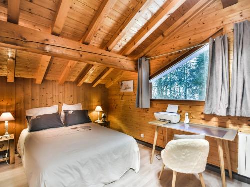 une chambre avec un lit, un bureau et une fenêtre dans l'établissement Chalet familial confortable 7 pers, 800m des pistes, terrasse, parking, WiFi, équipements modernes - FR-1-685-77, aux Gets