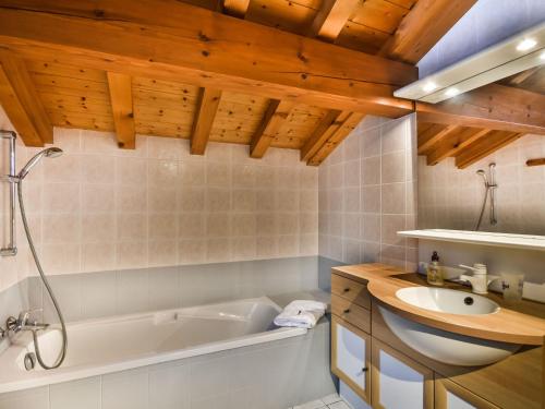 une salle de bain avec une baignoire blanche et un lavabo dans l'établissement Chalet familial confortable 7 pers, 800m des pistes, terrasse, parking, WiFi, équipements modernes - FR-1-685-77, aux Gets