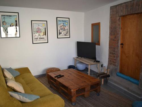 un salon avec un canapé et une table basse dans l'établissement Maison de Village Charmante, 3 Ch, Terrasse, à Proximité des Pistes et Commerces à Bolquère - FR-1-592-66, à Bolquère-Pyrénées 2000