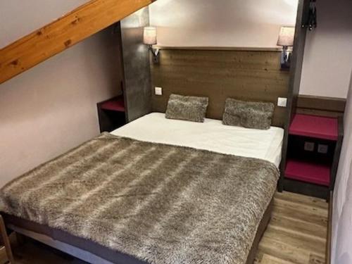 una piccola camera con un letto e due cuscini di Appartement Risoul, 1 pièce, 3 personnes - FR-1-330-574 a Risoul