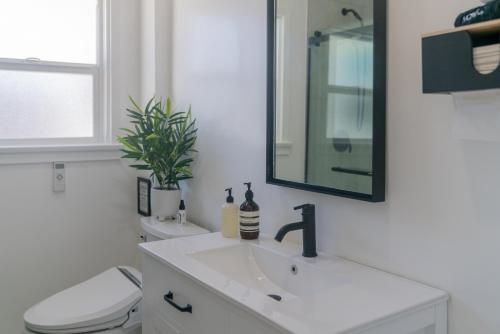 uma casa de banho com um lavatório, um WC e um espelho. em White Heaven House em Compton