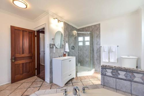a large bathroom with a shower and a sink at Charming 3BR Century Home in Downtown Barrie in Barrie