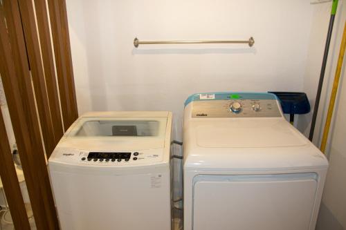 a refrigerator and a washer and dryer in a room at Casa de Nini in Santo Domingo