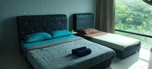una camera con due letti e una grande finestra di Syanaz Studio Apartment a Gua Musang