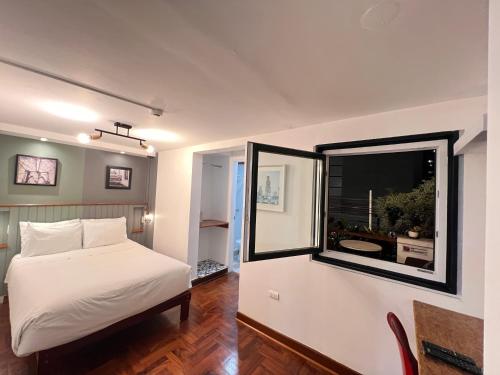 a bedroom with a bed and a large window at La Casa del Viajero in Lima