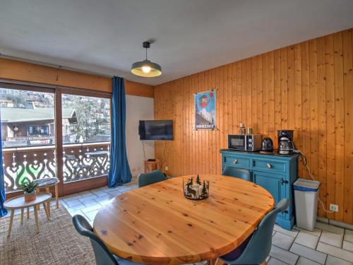 une salle à manger avec une table en bois et un balcon dans l'établissement Studio cosy au centre de Morzine, pour 4 pers avec balcon, proche des pistes et services - FR-1-524-124, à Morzine