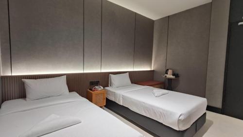 Postel nebo postele na pokoji v ubytování Urban Inn, Serai Wangi