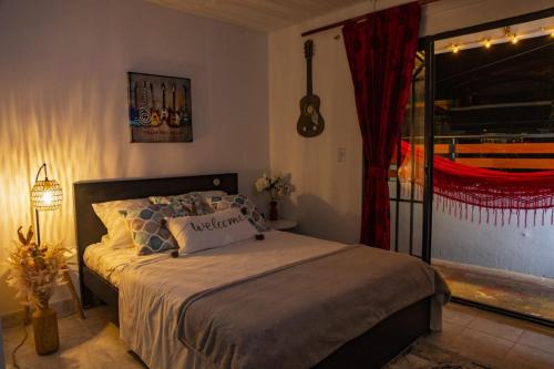 a bedroom with a bed and a guitar on the wall at Coliving7 Aparta Hotel & Habitaciones in Ibagué