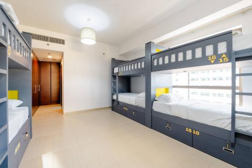 two bunk beds in a room with a hallway at Moonlight Hostel JBR in Dubai