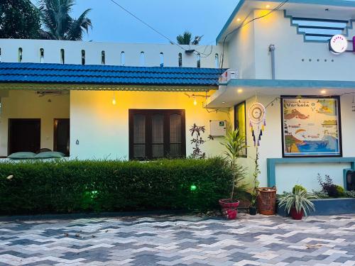 a white house with plants in front of it at Lavender residency in Varkala
