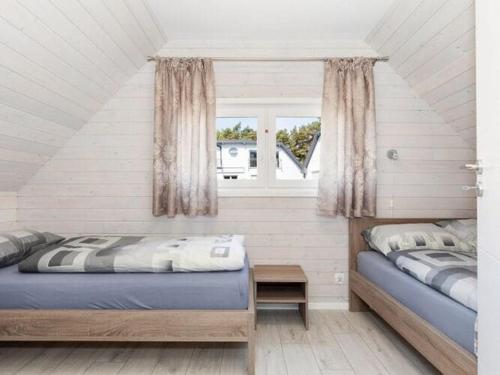 a bedroom with two beds and a window at Holiday cottages close to the beach, Pobierowo in Pobierowo