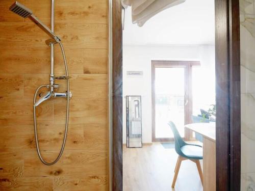 a shower in a room with a table and a chair at Comfortable terraced house Mielenko in Mielenko
